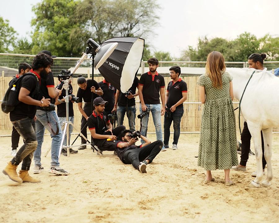 DCOP students lighting and photographing a model with a horse during a commercial location shoot