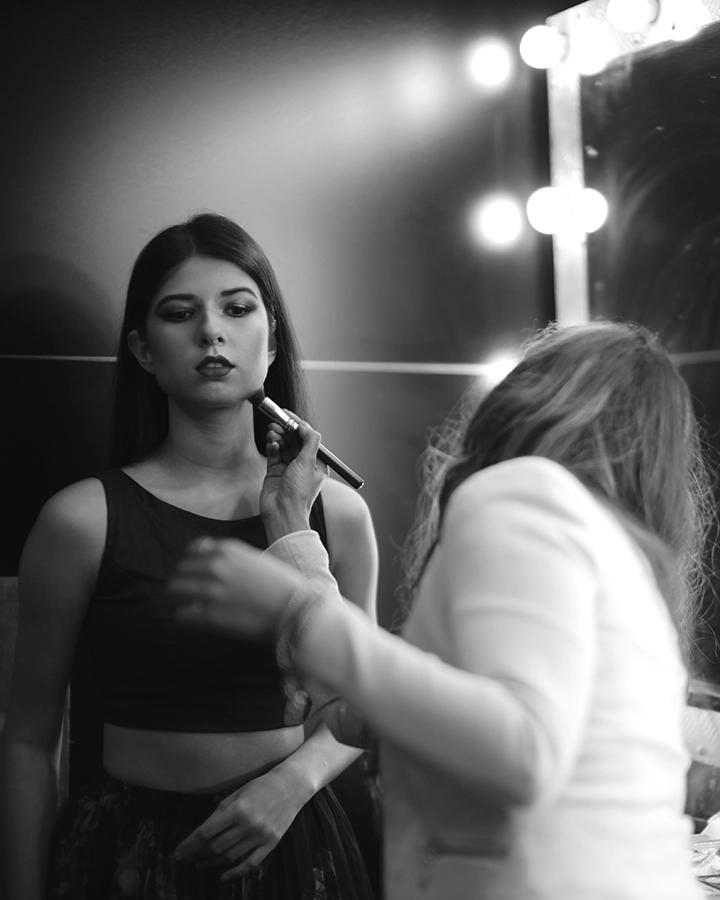 Makeup artist preparing a model during a black-and-white fashion shoot