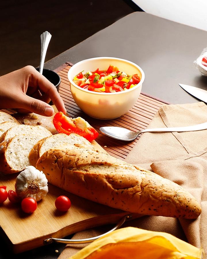 Food stylist arranging bread, vegetables and tableware for a commercial photography set