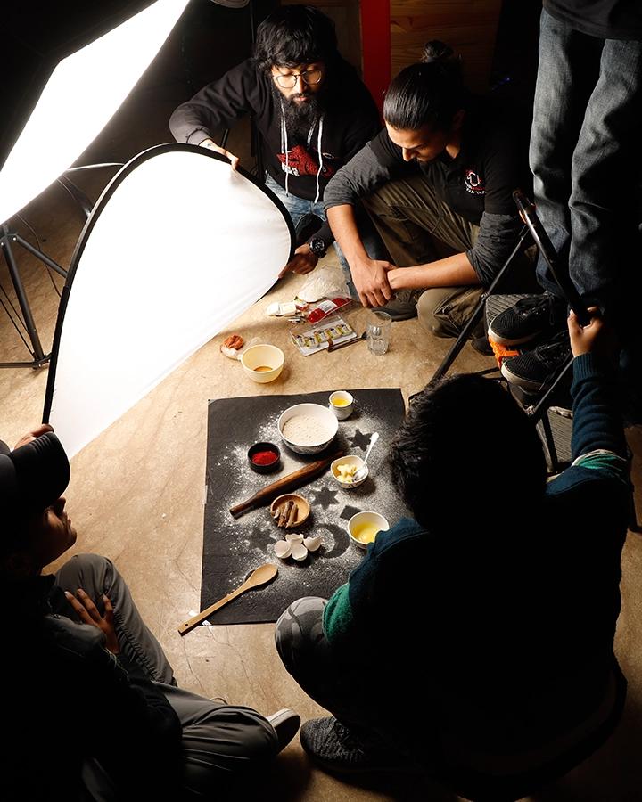 DCOP students arranging a styled food set with reflectors during a planning and presentation exercise