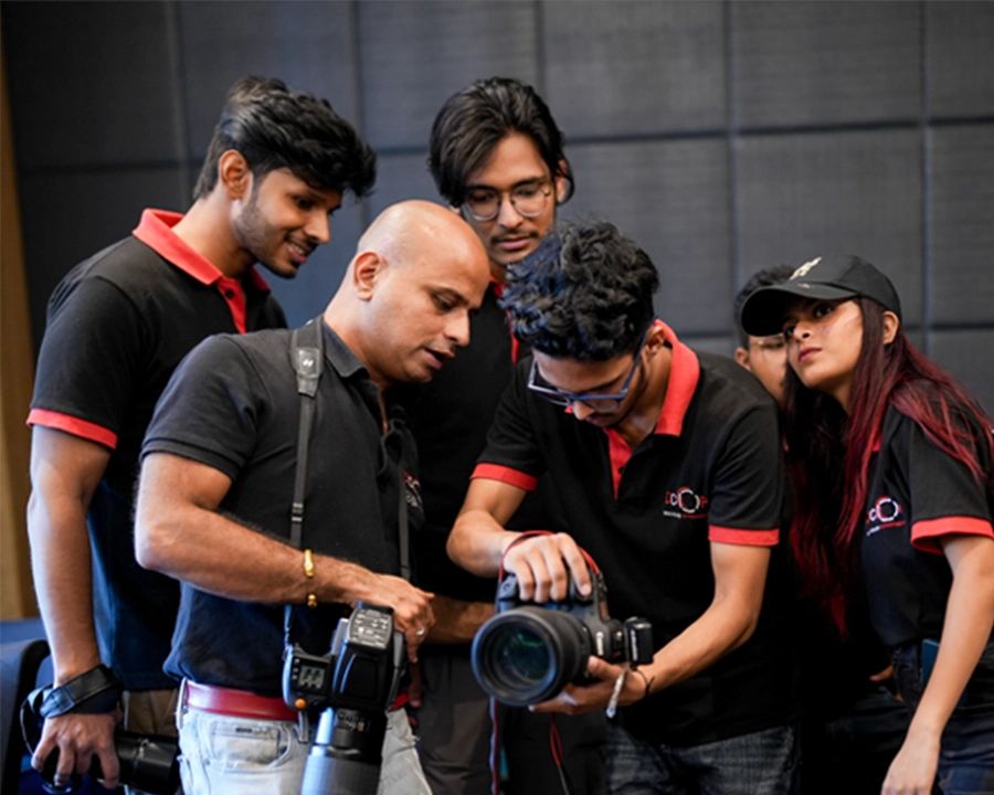 DCOP instructor and students reviewing a camera during a practical photography session