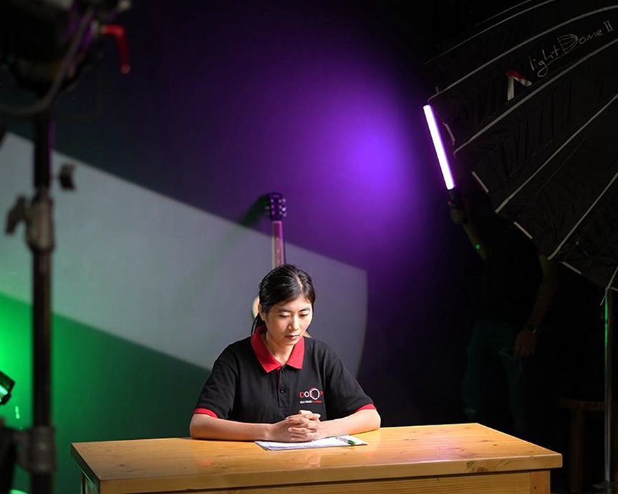 DCOP student seated on a commercial filmmaking set with studio lights and modifiers