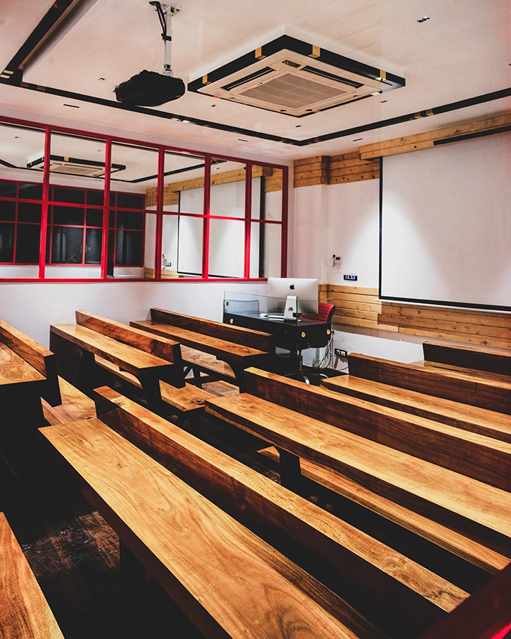 DCOP classroom with wooden bench seating, an iMac and a large projection screen