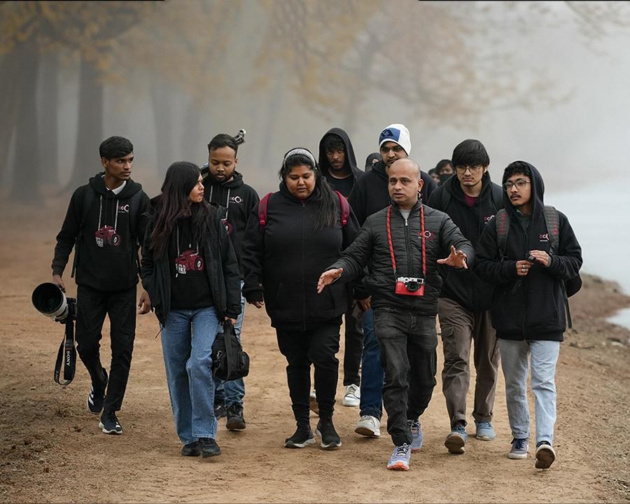 DCOP students and faculty walking beside a lake during an outdoor photography tour