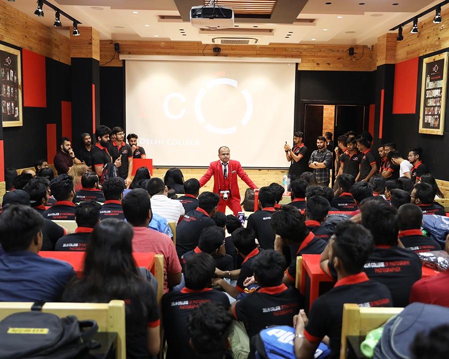DCOP instructor explaining a practical assignment to students in the auditorium